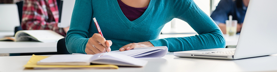 Jeune fille qui étudie entourée d'autres étudiant·es. Image représentant les sciences humaines, administration.