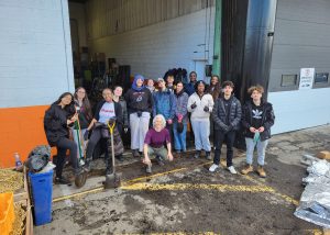 Groupe d'étudiantes et d'étudiants avec leur enseignante Héloïse Masse posant en groupe lors de l'activité de maraichage de Maisonneuve en commun.