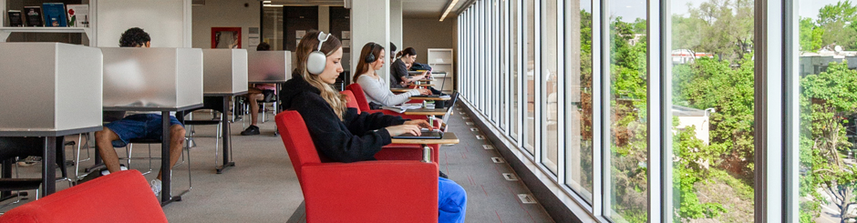 Jeune femme qui étudie près de la fenêtre dans la bibliothèque du Collège de Maisonneuve. Crédit photo: Katarina Soskic